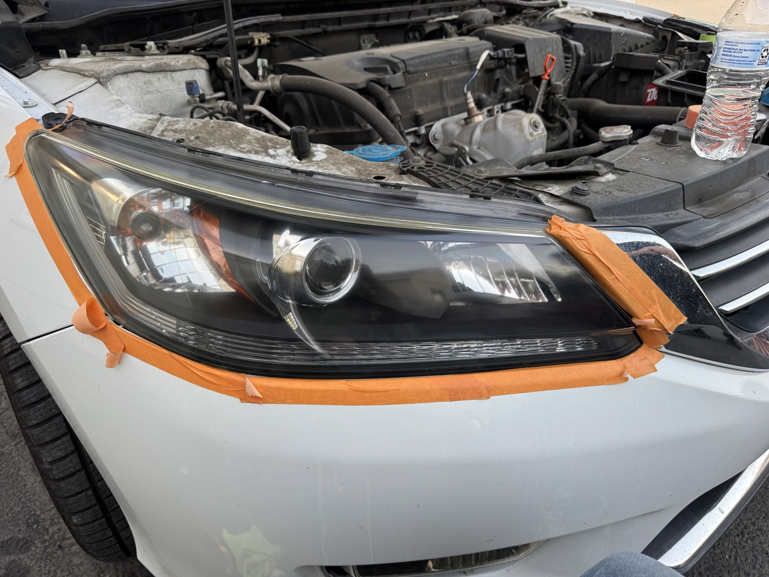 Close up of a restored headlight taped off and cleaned